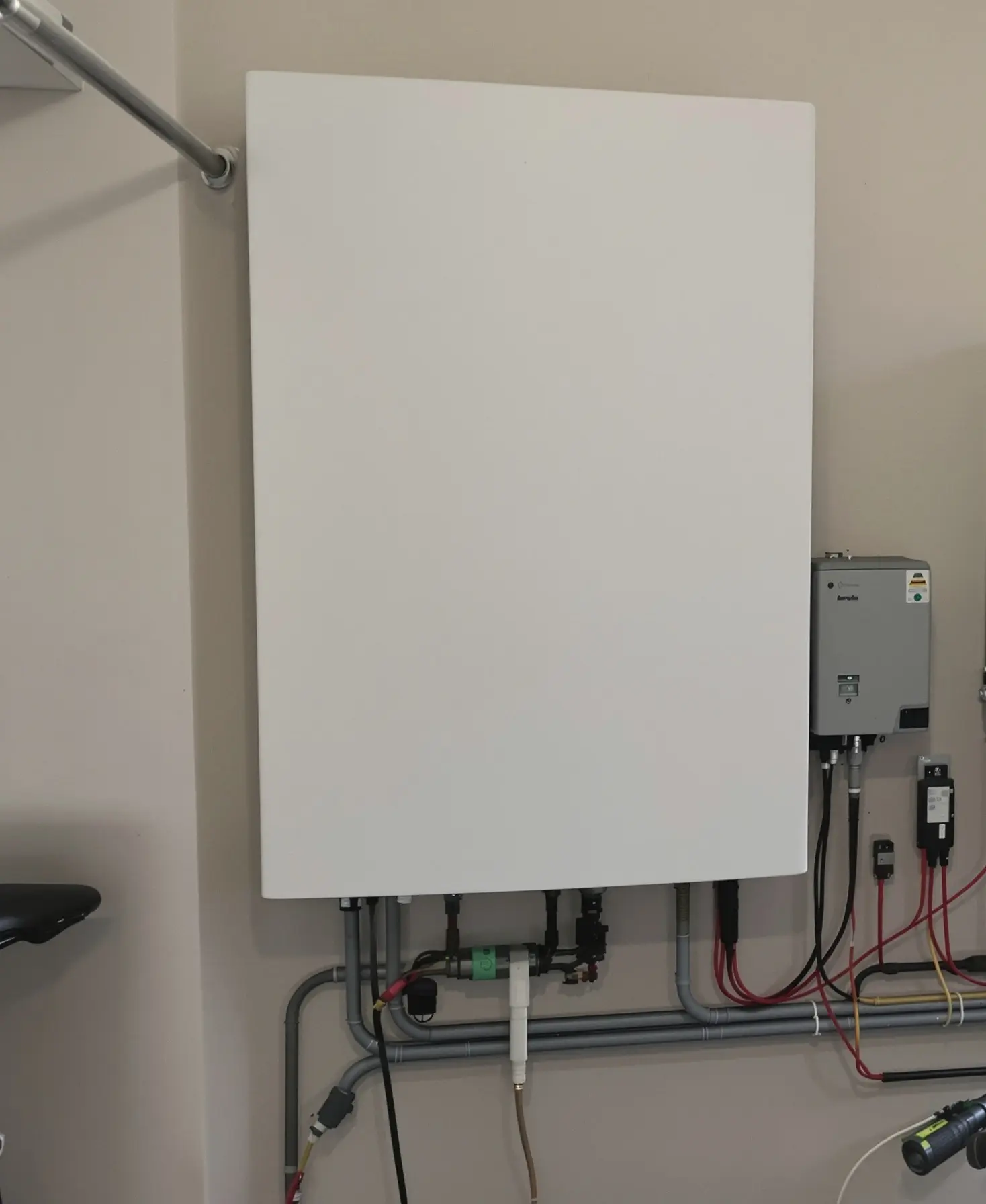 Batterie domestique et onduleur fixés au mur d'un garage